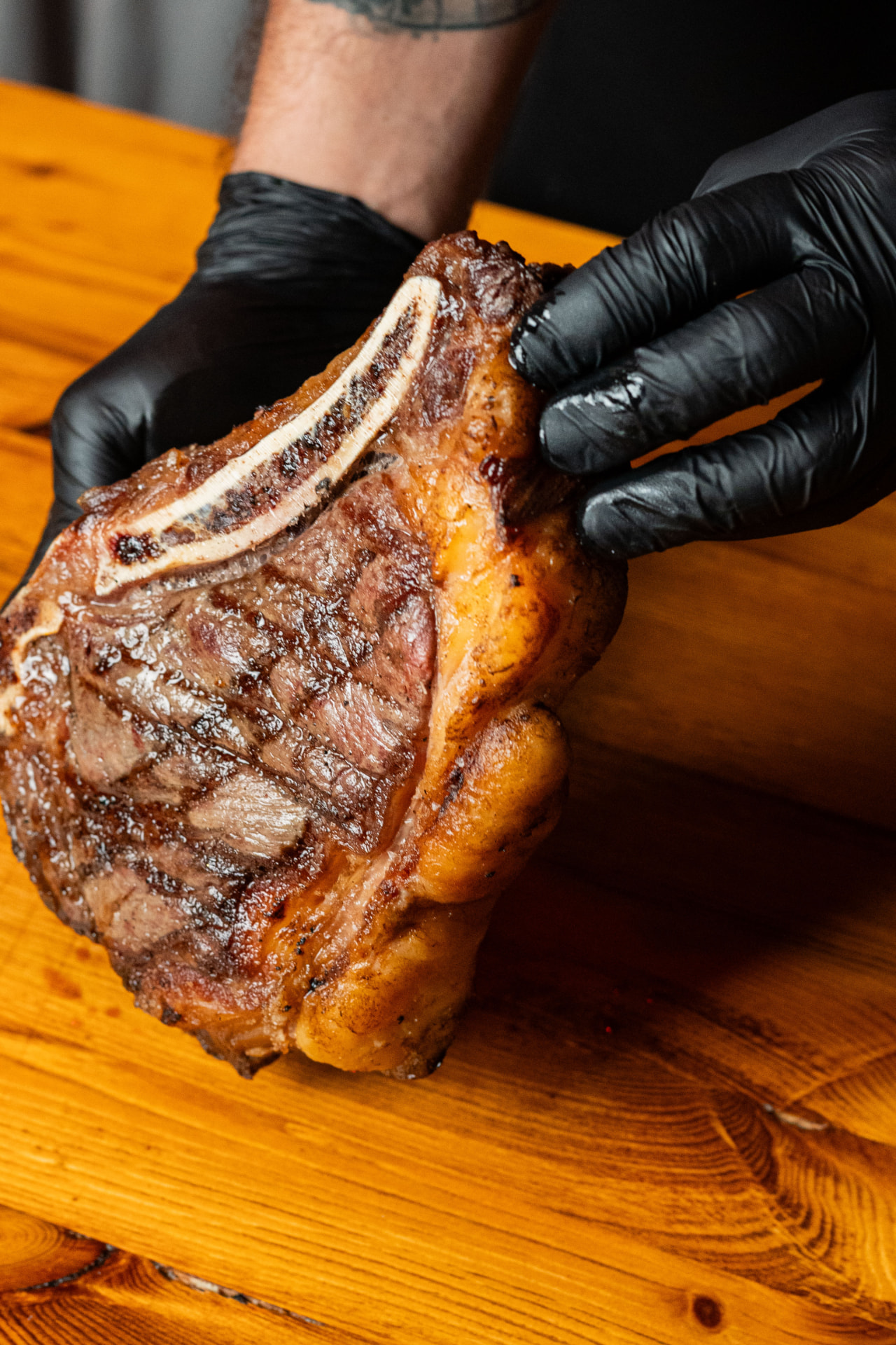 Chuletón con hueso asado, sostenido por el asador